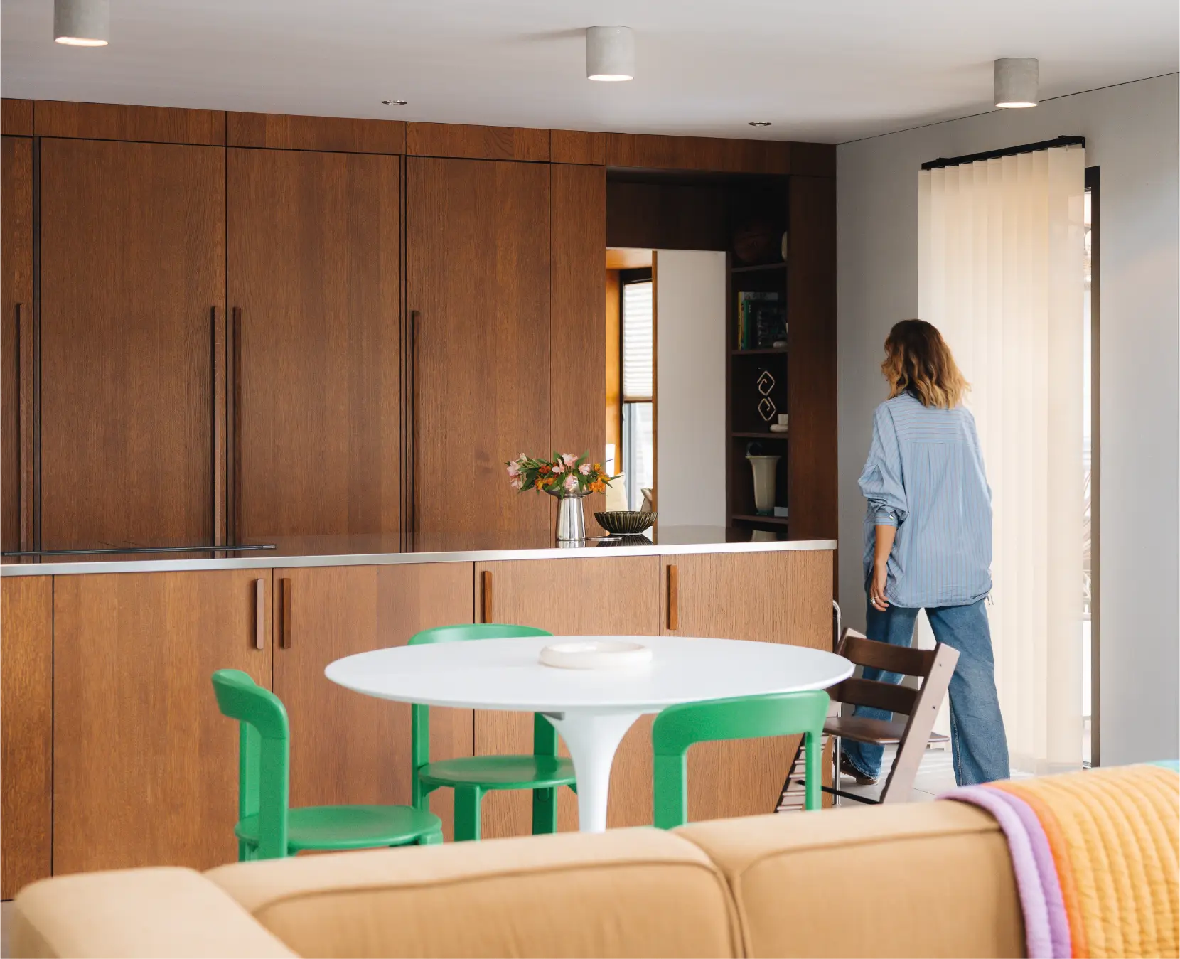 Cuisine Morel sur-mesure en bois teinte noyer avec aménagement en arche architecturale, créant une transition fluide vers la pièce de vie. Design intérieur premium et savoir-faire artisanal français depuis 1932.