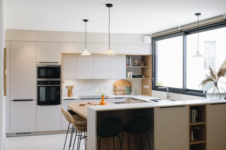 Cuisine Morel contemporaine lumineuse avec façades laque mate beige, îlot en bois sur-mesure et crédence marbre.