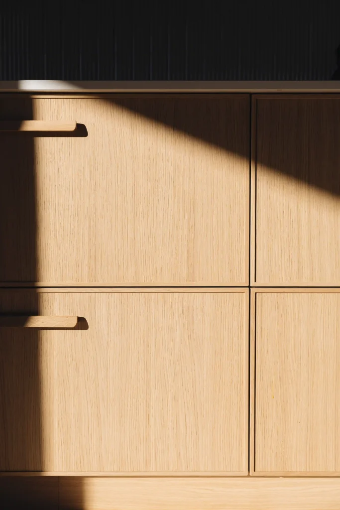 Détail des façades en chêne clair et poignées en bois massif du modèle Atelier Morel, dessiné par Bina Baitel
