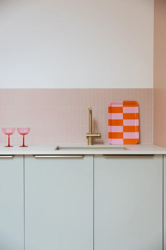 détail crédence rose poudré et façades vert d'eau avec robinetterie laiton